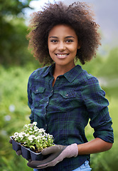 Image showing Black woman with flower, smile while gardening and botany, young gardener in portrait with growth outdoor. Happy female person with green fingers, growth and plants in nature with landscaping