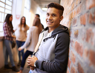 Image showing Education, happy and portrait of man in college hallway for studying, learning and scholarship. Future, smile and knowledge with student leaning on brick wall for university, academy and campus