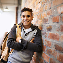 Image showing Learning, smile and portrait of man in school hallway for studying, education and scholarship. Future, happy and knowledge with male student leaning on brick wall for university, academy and campus