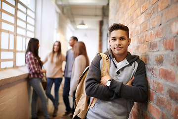 Image showing Education, arms crossed and portrait of man in college hallway for studying, learning or scholarship. Future, school and knowledge with student leaning on brick wall for university, academy or campus