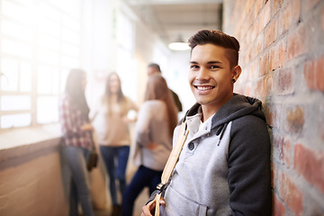 Image showing Education, smile and portrait of man in college hallway for studying, learning and scholarship. Future, happy and knowledge with student relax on brick wall for university, academy and campus