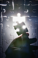 Image showing Hand, missing jigsaw puzzle and glow with light for problem solving, ideas and connection. Person, brain power and games with strategy, innovation or synergy for solution, link or creativity for goal