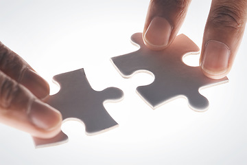 Image showing Hands, puzzle and strategy in closeup for problem solving, mindset or connection with glow by white background. Games, jigsaw and link for innovation, synergy and solution with people, team or help