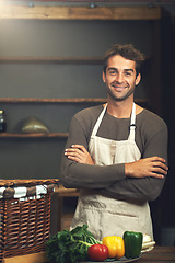 Image showing Chef, smile and portrait of man with arms crossed in rustic kitchen with vegetables for nutrition and vegan ingredients. Confidence, male cook and happy person from Norway ready to start cooking.