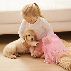 Image showing Child, golden retriever or dog playing together in a happy home with love, care and development. Girl kid and animal, puppy or pet in a tutu for dress up game as friends on the living room floor