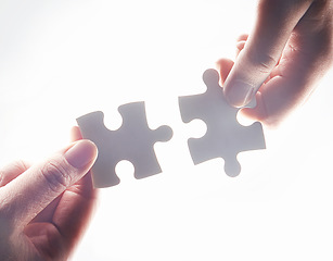 Image showing Hands, puzzle and strategy for teamwork, problem solving or together for support, glow or help by white background. Team building, jigsaw or games for innovation, synergy or solution in collaboration