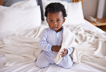 Image showing Playful, portrait and baby with a blanket in bed, waking up and playing in his home. Face, sweet and african boy toddler in a bedroom curious, having fun and sweet, cute and enjoying a morning indoor