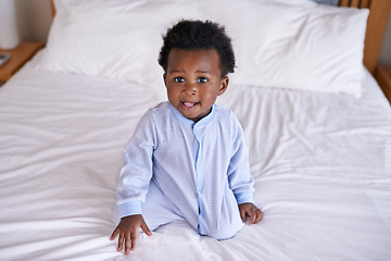 Image showing Black baby boy playing in bedroom, sitting on the bed with early childhood development. African male toddler, cute curious child with growth and learning, childcare and relax at family home