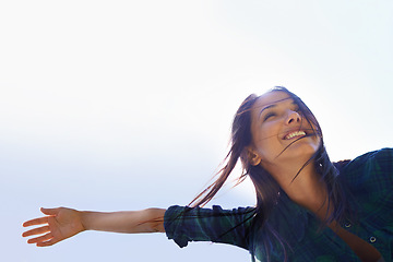 Image showing Mockup, sky and arms with a woman outdoor in nature for fun, freedom or adventure in summer from below. Energy, celebrate life or wellness with a happy young female person outside with a smile