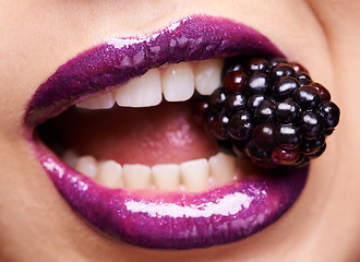 Image showing Woman lips closeup, purple lipstick with blackberry and makeup, shine and creativity with beauty. Fruit between female model teeth, cosmetics product and cosmetology, mouth with shiny lip gloss