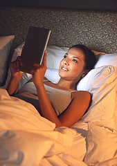 Image showing Woman, night and bedroom for reading on tablet, website or social media app to relax in home, hotel or apartment. Girl, mobile touchscreen and happy with ebook, movies or video on internet in bedroom