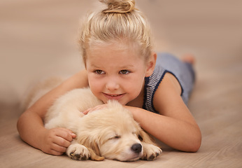 Image showing Girl kid hug her puppy, relax at home and happy with sleeping golden retriever dog and child with smile. Happiness, pet care and love with young female and her domestic animal lying on wood floor