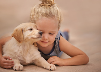 Image showing Young girl hug her dog, relax with peace and calm at home with golden retriever puppy and child. Mans best friend, pet care and love with female kid and her domestic animal lying on wood floor