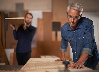 Image showing Carpenter team, men in collaboration and work in workshop on design project with vocation and creative DIY skill. Teamwork, carpentry and male employee saw wood with father and son working together