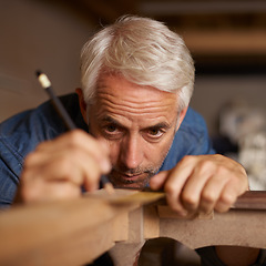 Image showing Focus, measurement and carpenter with pencil, furniture and designer table manufacturing workshop. Creativity, small business and professional carpentry, man working on sustainable diy wood project.