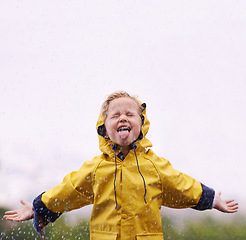 Image showing Girl outdoor, rain and play in space for mockup with tongue, happiness or winter fashion. Female kid, raincoat or playing with water, open hands and excited face on adventure with freedom in mock up