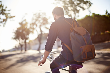 Image showing Bicycle, travel and back of man in street with lens flare for exercise, commute and cycling in morning. Transport, city and male cyclist on bike for eco friendly traveling, carbon neutral and journey