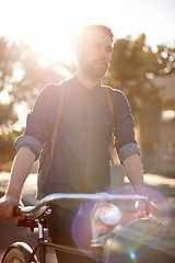 Image showing Walking, transport and man in road with bicycle for exercise, commute and cycling in morning. Travel, lens flare and male cyclist with bike for eco friendly traveling, carbon footprint and journey