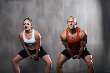 Image showing Fitness, people and weightlifting with kettlebell for workout or intense exercise together at gym. Serious man and woman lifting weight for strong exercising, power or strength in training indoors