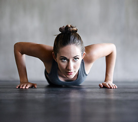 Image showing Pushup, fitness and woman on a floor for training, cardio and endurance at gym. Push up, exercise and female athlete at a health center for core, strength and ground workout with determined mindset