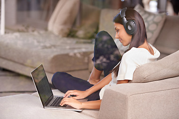 Image showing Headphones, typing and woman with laptop on home sofa listening to music, audio or streaming movies. Happy female student relax on couch to listen to podcast or research to learn language on internet