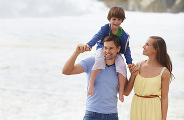 Image showing Family, summer and walking outdoor at beach for travel holiday with a smile and fun. A man, woman and child or son on shoulders while playing together on vacation at sea with happiness, love and care