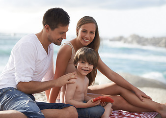 Image showing Family, child and watermelon portrait at beach on travel holiday in summer with a smile for fun. A man, woman and kid eating fruit on a picnic while together on vacation at sea for happiness and care