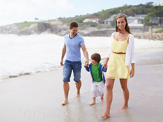 Image showing Family, portrait and holding hands while walking at beach for travel, fun or holiday in summer with a smile. Man, woman and child or son walk together on vacation at sea with happiness, love and care