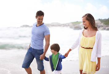 Image showing Family, child and holding hands while walking at beach for travel, fun or holiday in summer with a smile. Man, woman and kid or son walk together on vacation at sea with happiness, love and care