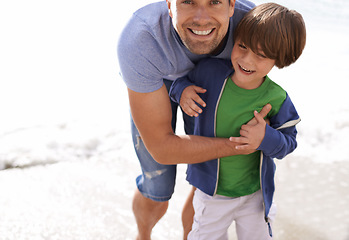 Image showing Father, child or family fun at beach for travel or holiday in summer with a smile, love and hug. A man and kid or son playing and laughing together on vacation at sea with sunshine and happiness