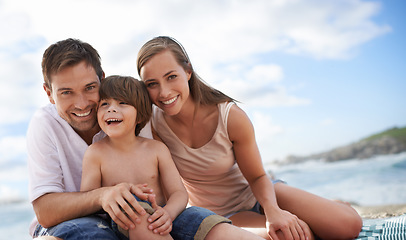 Image showing Happy family, child and portrait at beach for travel holiday in summer with a smile and fun. A man, woman and kid or son together on vacation, adventure or picnic at sea with a blue sky and happiness