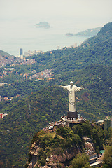 Image showing Landscape, statue and aerial of Christ the Redeemer on hill for tourism, sightseeing and travel destination. Traveling, Rio de Janeiro and view of monument, sculpture and city landmark on mountain