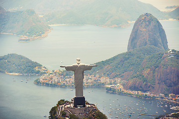 Image showing Statue, monument and Christ the Redeemer on mountain for tourism, sightseeing and travel destination. Traveling, Rio de Janeiro and aerial view of symbol, sculpture and city landmark by Brazil ocean