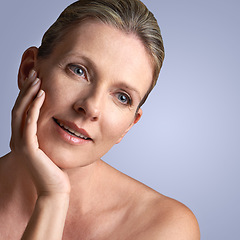 Image showing Face, beauty and mature woman with skincare or cosmetic facial isolated in a blue studio background. Cosmetics, self care and old female model calm with natural skin due to anti aging dermatology