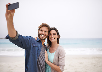 Image showing Love, selfie and couple hug at beach for travel, photo and freedom outdoors together. Smile, embrace and traveling influencer people live streaming for blog, followers or social media profile picture