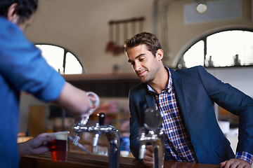 Image showing Professional man at pub, order beer and relax on a break, leaning against countertop in bistro with alcohol drink. Hospitality industry, male business person at restaurant and enjoying social time