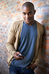 Image showing School, phone and portrait of black man at brick wall for social media, technology or internet. Education, learning and scholarship with student at university for connection, contact or text message