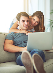 Image showing Couple, laptop and hug on home sofa while on internet for remote work or streaming movies. A man and woman together in a house while happy about online shopping, search or internet connection