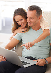 Image showing Happy couple, computer and pointing on home internet for online planning, website and to check application together. Hug, love and mature partner, woman or people on sofa reading on laptop technology