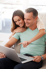 Image showing Laptop, pointing and mature couple on home internet for online planning, website and to check application together. Hug, love and happy woman, partner or people on sofa, choice or reading on computer