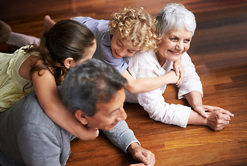 Image showing Hug, floor or happy grandparents with children playing together in lovely family home in retirement. Senior grandma, piggyback or kids siblings relaxing or bonding to enjoy quality time with old man