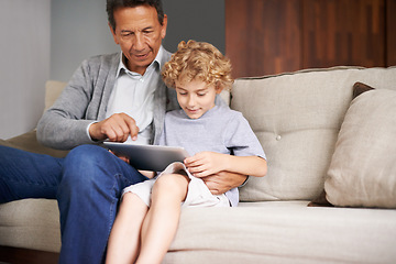 Image showing Tablet, child or grandfather typing on online to search for games on internet in retirement at home to relax. Grandparent or young kid enjoying watching videos with a senior or mature old man on sofa