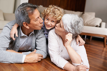 Image showing Floor, portrait or grandparents kiss a happy kid playing or hugging with love or care in family home. Smile, grandma or old man relaxing or bonding to enjoy time with child or cute boy in retirement