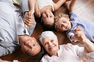 Image showing Portrait, holding hands or grandparents on the floor with happy kids smiling together in family home. Grandma in retirement, relax or fun children siblings bonding to enjoy quality time with old man