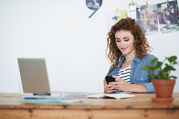 Image showing Woman, designer and texting on smartphone in creative startup, photography agency and office desk. Young business student typing on cellphone, online app and reading notification on mobile technology