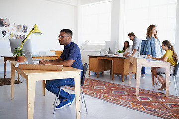 Image showing Coworking, office or black man typing on laptop working on a creative project, digital or online research. Computer, planning or focused African designer working on website in startup company agency