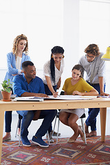 Image showing Diversity, business people and blueprint in meeting for planning, construction or strategy at the office. Architect group working together on document in collaboration for floor plan at the workplace