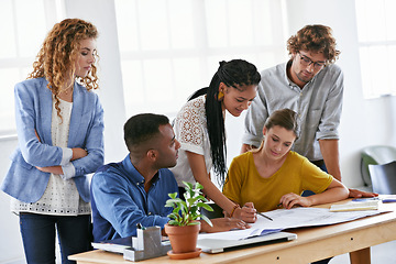 Image showing Diversity, business people and writing on blueprint in planning, brainstorming or design at the office. Architect group working on document, floor plan or strategy for construction at the workplace