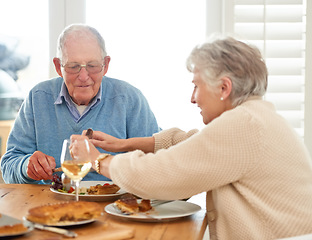 Image showing Love, help and senior couple eating lunch together in the dining room of their modern home. Happy, date and elderly man and woman in retirement talking, bonding and enjoying meal or food in a house.