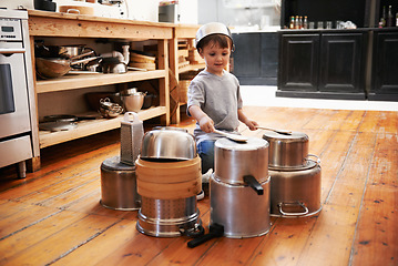 Image showing Sound, boy and child on drums or pots on a floor, happy and playing fun music in house. Smile, creative or kid with pans for musical entertainment, silly or enjoying game in a kitchen on the weekend